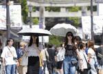 　猛暑日が続く福岡県太宰府市で日傘を差して歩く人たち＝８月23日