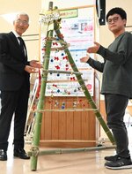 イベント期間中に飾り付けるクリスマスツリーをお披露目した小林実行委員長（右）と江崎学長＝１８日、鳥取市若葉台北１丁目の鳥取環境大