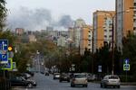 　倉庫への爆撃で上がった煙が漂う市街地＝２１日、ウクライナ東部ドネツク州（ロイター＝共同）