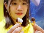 　チョコレート菓子「きのこの山」（右）に似せたワイヤレスイヤホン＝２５日午後、千葉県成田市