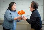 　「さいがい・つながりカフェ」の集まりで誕生日の女性にクンシランの花束を渡す渡部まゆみ＝２０２４年３月、さいたま市の男女共同参画推進センター