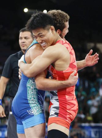 　男子フリー７４キロ級決勝で敗れ、ウズベキスタン選手（左）と健闘をたたえ合う高谷大地＝パリ（共同）