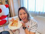 　提供されたピザを手に笑顔を見せる競泳女子の鈴木聡美＝福岡市（味の素（株）提供）