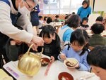 食べ終わったエノハにやかんで湯を注いでもらう園児＝３０日、境港市中野町のあがりみち保育園