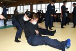 傷病者役の隊員を後ろから抱きかかえ、滑らせるように搬送する隊員＝２６日、鳥取市下味野の鳥取刑務所