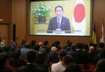 　会合で岸田首相の動画メッセージを聞く参加者ら＝１０日、ベルリン（共同）