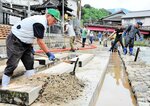 源泉「荒湯」近くの足湯にたまった土砂をかき出す関係者＝１７日、新温泉町湯の湯村温泉