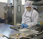 　北海道白糠町にある「イミュー」の加工場で、ホッキ貝の処理をする作業員＝３月