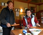 住民や観光客に笑顔で接客する早瀬さん夫妻＝１２月上旬、智頭町新田の「清流の里　新田」