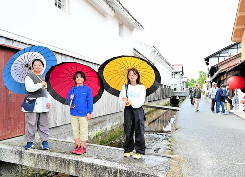 白い漆喰（しっくい）の壁とレトロな町並みに映える色鮮やかな傘