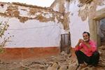 　全壊した自宅跡に座り込むアラビ・ゴホバルさん＝７日、モロッコ・アミズミズ郊外（共同）