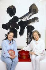 　輪島塗の印泥入れを手にする金沢翔子さん（左）、墨つぼに触れる母泰子さん＝東京都大田区