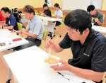 グルメを試食する審査員＝５日、境港市竹内団地の境夢みなとターミナル