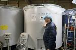 　日本酒のタンクの前で解説する「夢酒蔵」代表の大辺誠さん＝２０２４年１月、滋賀県高島市