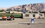 　アフガニスタンのバーミヤン遺跡を望む地区に建設されているガソリンスタンド。奥に見える崖のくぼみが遺跡の西大仏＝５月（共同）