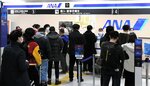 全日空のカウンターに並ぶ乗客ら＝２日午後７時１５分、鳥取県境港市の米子鬼太郎空港