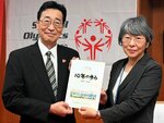 西尾館長（右）に創立１０周年記念誌を手渡した山本理事長＝２５日、鳥取県立博物館