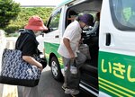 両手に買い物袋を提げて、いきいき社バスに乗り込む住民ら＝鳥取市河原町布袋のエスマート鳥取南ＩＣ店