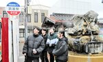 温泉熱を利用してバス停の表示板を点灯させる生徒たち＝３日、ＪＲ浜坂駅前