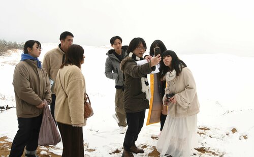  雪原となった鳥取砂丘で、ショートムービーの撮影に臨む関係者＝２日、鳥取砂丘西側エリア 
