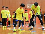 子どもたちにステップワークを指導する長谷川選手（右）＝２７日、倉吉体育文化会館