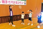 長谷川さん（左）から素振りの仕方を学ぶ子どもたち