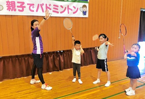 長谷川さん（左）から素振りの仕方を学ぶ子どもたち