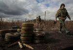 　ウクライナ東部ハリコフ州で除去された地雷の近くを歩くウクライナ国家警察の要員ら＝２４日（ロイター＝共同）