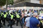 　７月３１日、ロンドンの首相官邸前で衝突する反不法移民のデモ参加者と警察官（共同）