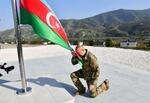 　アゼルバイジャン国旗を掲揚するアリエフ大統領＝１５日、同国ホジャリ（同国大統領府提供、ゲッティ＝共同）