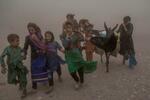 　砂嵐の中、支援物資を運ぶ少女ら＝１２日、アフガニスタン・ヘラート州（ＡＰ＝共同）