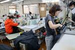　「エイ・アイプランニング」の縫製工場で働く従業員ら＝１７日、東京都江東区