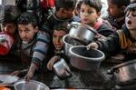 　５日、パレスチナ自治区ガザのラファで、食料を求め鍋を差し出す子どもたち（ゲッティ＝共同）
