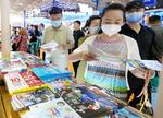 　国際旅行博覧会で日本の観光地のパンフレットを手に取る人たち＝６月、北京（共同）