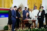 　昨年６月、米ホワイトハウスで、ＬＧＢＴＱなど性的少数者を擁護するための大統領令に署名するバイデン大統領（中央）（ロイター＝共同）