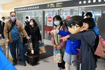 コナン君との記念撮影を楽しむツアー客ら＝２８日、鳥取市の鳥取砂丘コナン空港