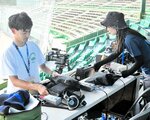 放送席の機材を準備するスタッフ＝４日、鳥取市布勢のヤマタスポーツパーク野球場
