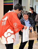 ようこそ　
ＪＲ西日本の社員から記念品を受け取る乗客＝６日、ＪＲ米子駅