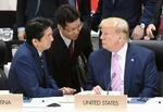 　２０１９年６月、Ｇ２０大阪サミット初日の討議を前に、トランプ米大統領と話す安倍首相（左）。中央は通訳を務める高尾直氏＝大阪市