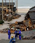 　石川県輪島市門前町黒島町の地震で倒壊した家屋。電力復旧のため関係者が作業していた＝２０日午後