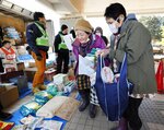 ０歳児のひ孫のため、粉ミルクなどの支援物資を受け取った古川清子さん（７７・手前左）。「避難生活が長引いて物も不足がちになるところ、本当にありがたいです」と話した＝４日午後、石川県珠洲市