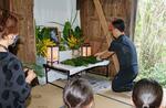 　「一村忌」で祭壇にソテツの葉を供える参加者＝１０日、鹿児島県奄美市