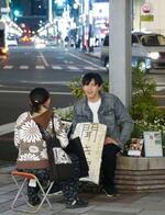 　名古屋駅前の路上で、「聞き屋」として人の話に耳を傾ける水野怜恩さん（仮名）＝２０２４年４月