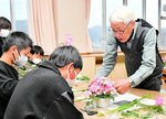 井口さん（右）のアドバイスを受けて花を飾る子どもたち