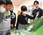 土石流の様子を検証できる模型で、砂防ダムの必要性を学ぶ児童ら＝１７日、鳥取市本町１丁目の遷喬小