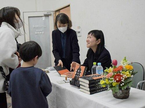 笑顔でファンと交流する角田さん（右）＝２３日、鳥取市叶の今井書店吉成店
